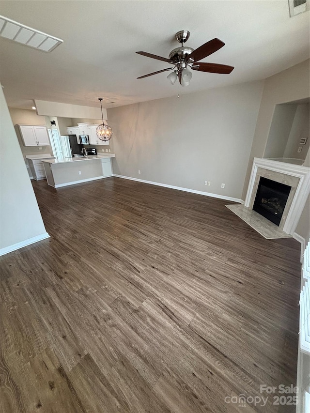 4151 Town Center Rd, Harrisburg, NC 28075 - unfurnished living room featuring a ceiling fan, a high end fireplace, dark wood-type flooring, and baseboards