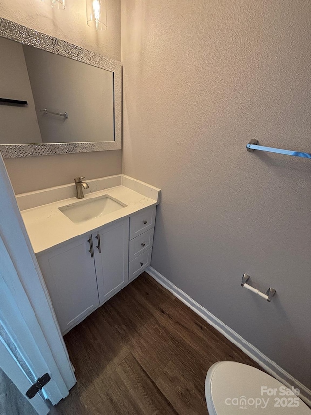 4151 Town Center Rd, Harrisburg, NC 28075 - half bathroom with wood finished floors, vanity, toilet, and baseboards