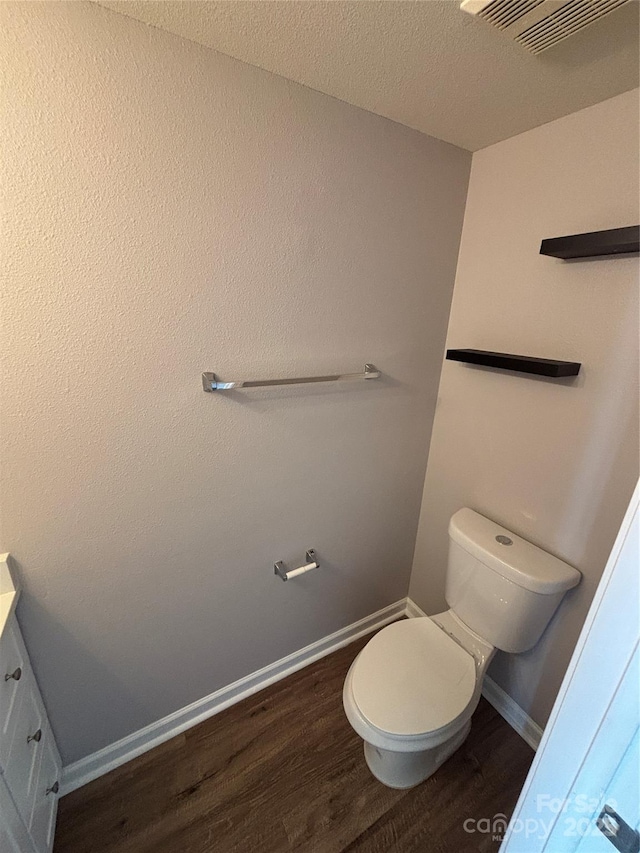 4151 Town Center Rd, Harrisburg, NC 28075 - bathroom featuring wood finished floors, toilet, baseboards, vanity, and a textured ceiling