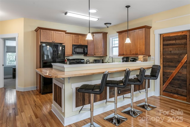 26 Byrdcliffe Ln, Asheville, NC 28805 - kitchen with black appliances, a breakfast bar, a peninsula, and plenty of natural light