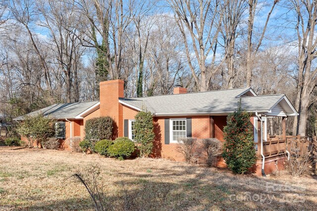 3515 Back Creek Church Rd, Charlotte, NC 28213 - view of home's exterior with brick siding, a chimney, a shingled roof, and a yard