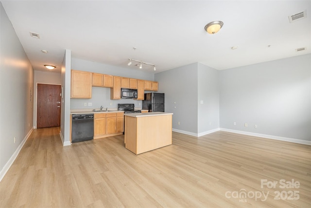 411 W Washington St, Greensboro, NC 27401 - kitchen with black appliances, a sink, light wood finished floors, light countertops, and baseboards