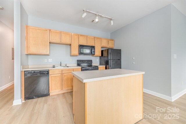 411 W Washington St, Greensboro, NC 27401 - kitchen with black appliances, a sink, light wood finished floors, and light brown cabinets
