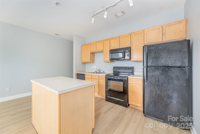 411 W Washington St, Greensboro, NC 27401 - kitchen featuring black appliances, light brown cabinets, light wood finished floors, and a center island
