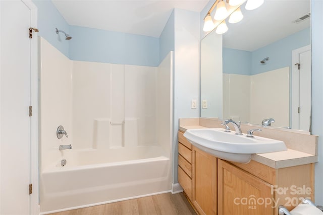 411 W Washington St, Greensboro, NC 27401 - bathroom with vanity, shower / bathtub combination, and wood finished floors
