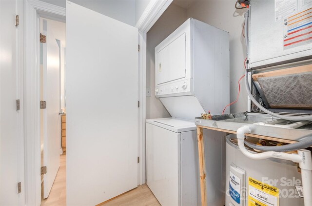 411 W Washington St, Greensboro, NC 27401 - washroom with stacked washer / dryer, electric water heater, and light wood-type flooring
