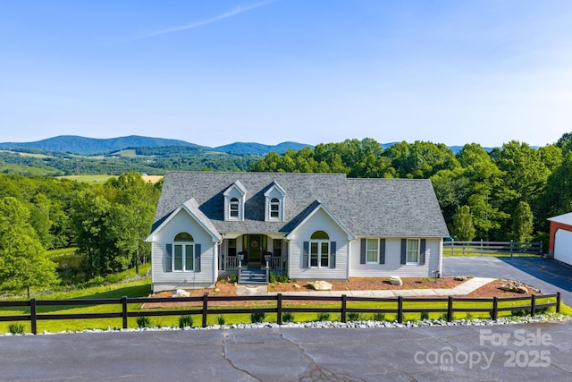 347 Hickory Mountain Rd, Sparta, NC 28675 - cape cod home with a porch, a fenced front yard, a mountain view, and a shingled roof