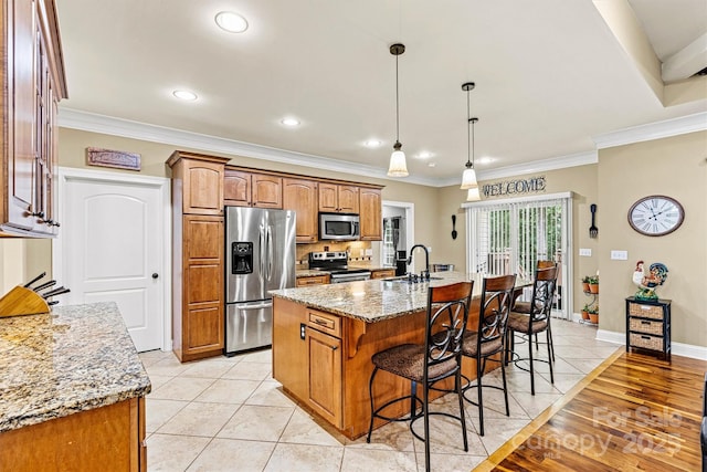 1616 Indian Springs Dr NW, Conover, NC 28613 - kitchen featuring appliances with stainless steel finishes, a kitchen bar, a center island with sink, light stone counters, and a sink