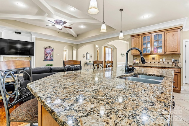 1616 Indian Springs Dr NW, Conover, NC 28613 - kitchen featuring a sink, arched walkways, a center island with sink, light stone counters, and backsplash
