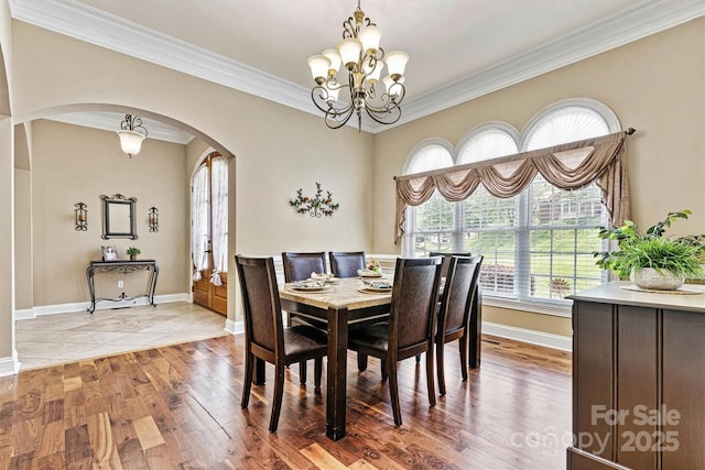 1616 Indian Springs Dr NW, Conover, NC 28613 - dining area with arched walkways, ornamental molding, a chandelier, baseboards, and wood finished floors
