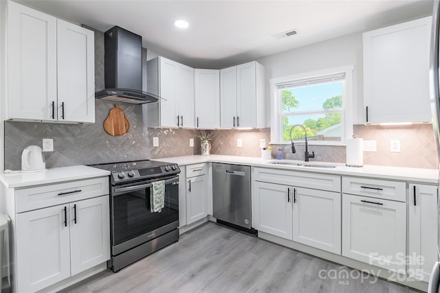 2116 Eastway Dr, Charlotte, NC 28205 - kitchen featuring wall chimney range hood, stainless steel appliances, a sink, light countertops, and recessed lighting