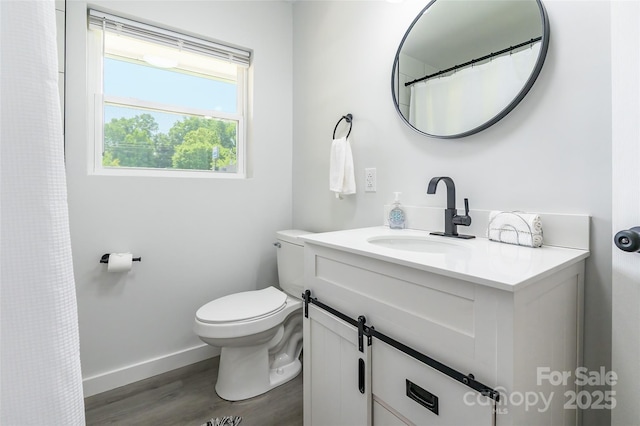 2116 Eastway Dr, Charlotte, NC 28205 - full bathroom with toilet, vanity, wood finished floors, and baseboards