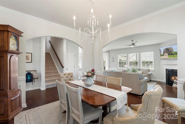 17637 Snug Harbor Rd, Charlotte, NC 28278 - dining space with arched walkways, wood finished floors, ceiling fan, crown molding, and a glass covered fireplace