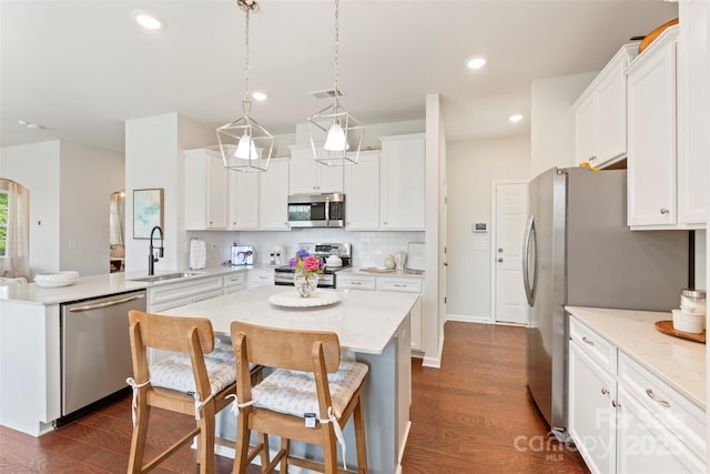 17637 Snug Harbor Rd, Charlotte, NC 28278 - kitchen featuring appliances with stainless steel finishes, a sink, dark wood finished floors, white cabinetry, and decorative backsplash