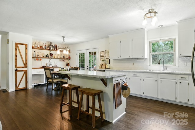 5378 Westwood Dr, Granite Falls, NC 28630 - kitchen with dark wood-style floors, white cabinetry, decorative backsplash, a textured ceiling, and a kitchen island