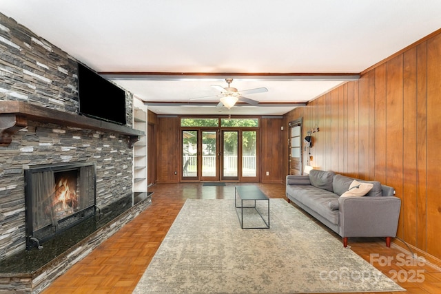 1107 Fairfield Dr, Gastonia, NC 28054 - living room with ceiling fan, wooden walls, a large fireplace, and beamed ceiling