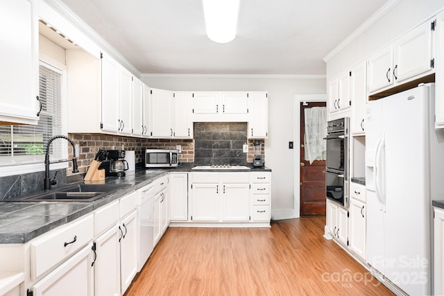1107 Fairfield Dr, Gastonia, NC 28054 - kitchen with appliances with stainless steel finishes, a sink, light wood finished floors, backsplash, and white cabinets