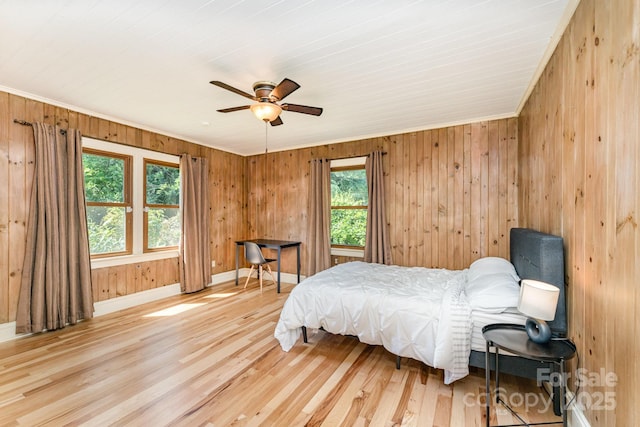 1107 Fairfield Dr, Gastonia, NC 28054 - bedroom with multiple windows, light wood-style flooring, wood walls, baseboards, and a ceiling fan