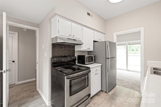 5949 Quail Hollow Rd Unit E, Charlotte, NC 28210 - kitchen with stainless steel appliances, under cabinet range hood, white cabinetry, and light wood-type flooring