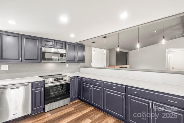 5354 Sherrills Ford Rd, Catawba, NC 28609 - kitchen with stainless steel appliances, wood finished floors, decorative light fixtures, light stone countertops, and recessed lighting