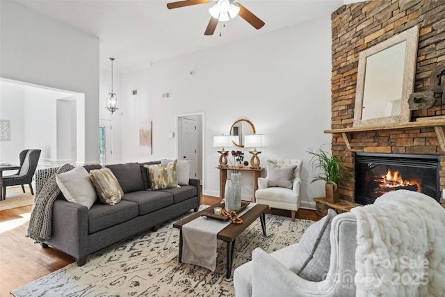 3831 Riceland Pl, Charlotte, NC 28216 - living area featuring wood finished floors, a ceiling fan, a high ceiling, and a fireplace