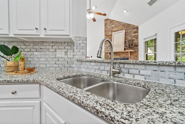 3831 Riceland Pl, Charlotte, NC 28216 - kitchen with tasteful backsplash, white cabinets, lofted ceiling, light stone countertops, and ceiling fan