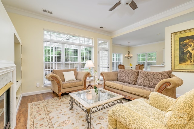13402 Mccoy Rd, Huntersville, NC 28078 - living room with ornamental molding, ceiling fan, a chandelier, a glass covered fireplace, and wood finished floors