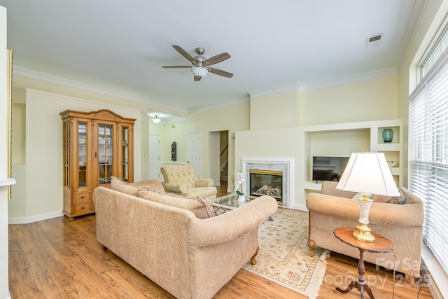 13402 Mccoy Rd, Huntersville, NC 28078 - living room featuring crown molding, ceiling fan, light wood-style floors, and a high end fireplace