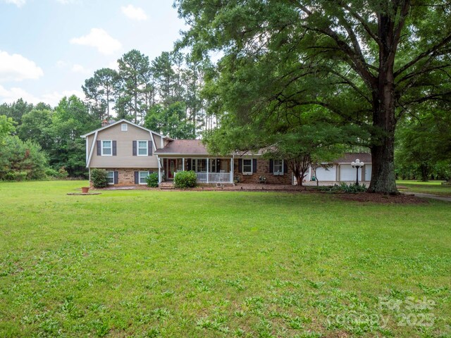 409 Ridge Rd, Clover, SC 29710 - tri-level home featuring a front yard, brick siding, an attached garage, and a porch