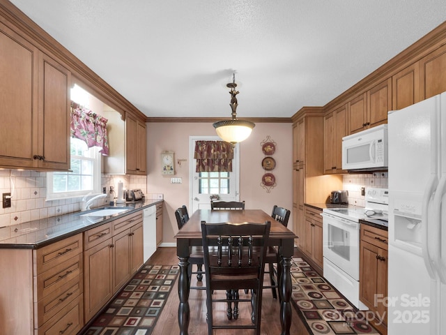 409 Ridge Rd, Clover, SC 29710 - kitchen with white appliances, a sink, dark countertops, brown cabinets, and decorative backsplash