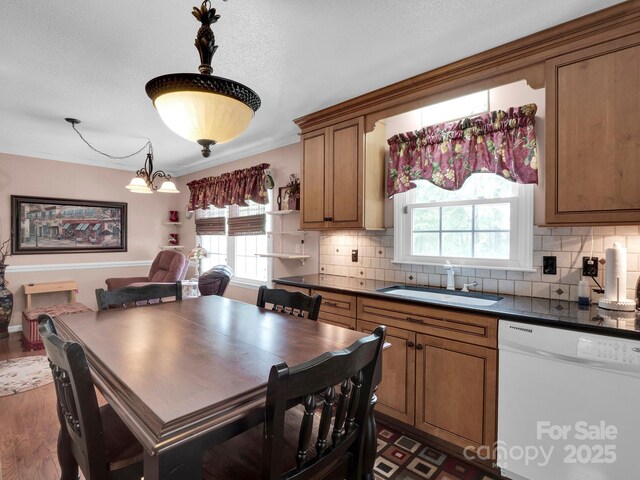 409 Ridge Rd, Clover, SC 29710 - kitchen featuring white dishwasher, a sink, dark countertops, brown cabinets, and backsplash