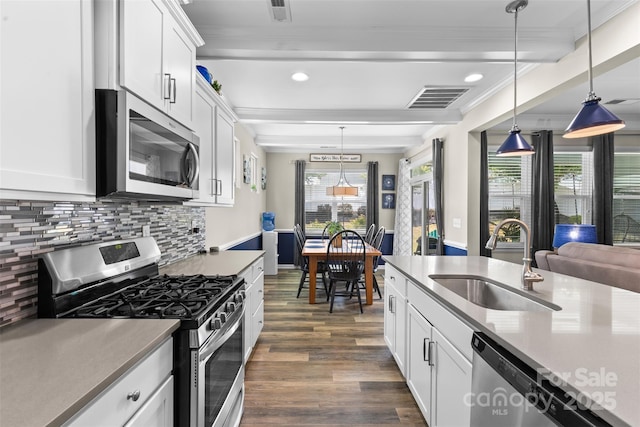 5059 Fenwick Ct, Lancaster, SC 29720 - kitchen featuring appliances with stainless steel finishes, ornamental molding, dark wood-type flooring, tasteful backsplash, and white cabinets