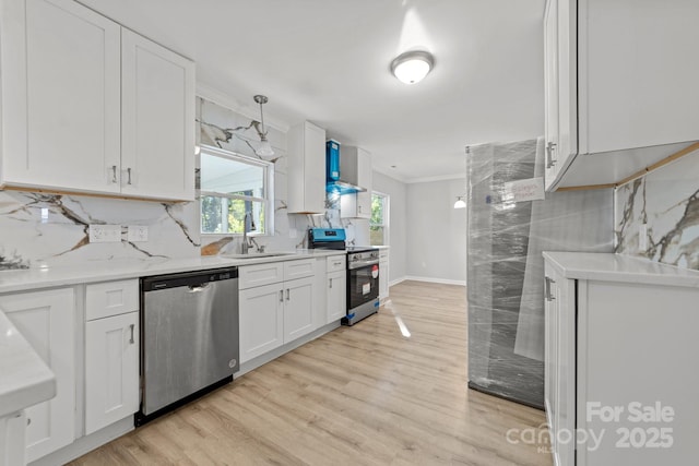 4918 Tyne Dr, Durham, NC 27703 - kitchen with appliances with stainless steel finishes, white cabinetry, a sink, decorative backsplash, and light wood-style flooring