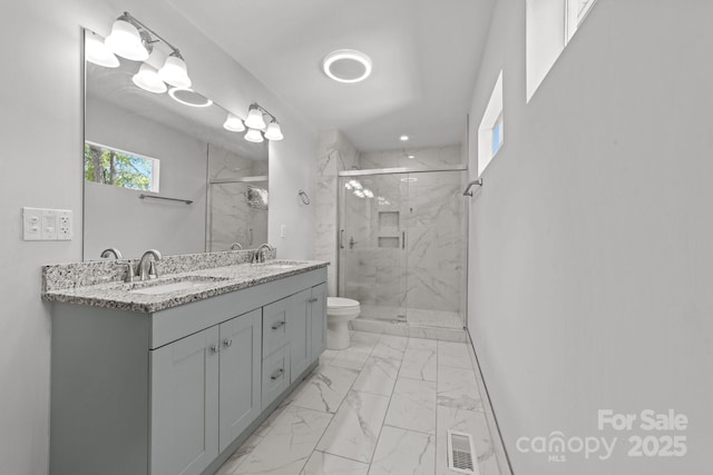 4918 Tyne Dr, Durham, NC 27703 - bathroom with marble look tile flooring, toilet, a marble finish shower, and double vanity