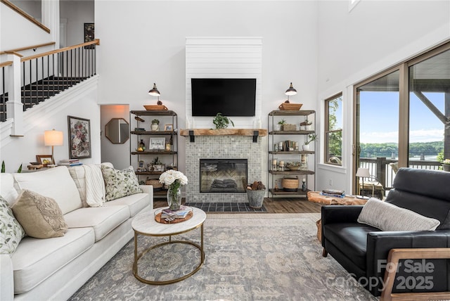 5888 Wood Duck Way, Catawba, NC 28609 - living room featuring wood finished floors, a high ceiling, stairs, and a tiled fireplace