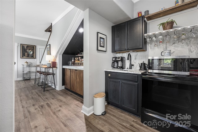 5888 Wood Duck Way, Catawba, NC 28609 - indoor wet bar with stainless steel microwave, light wood finished floors, black / electric stove, and ornamental molding