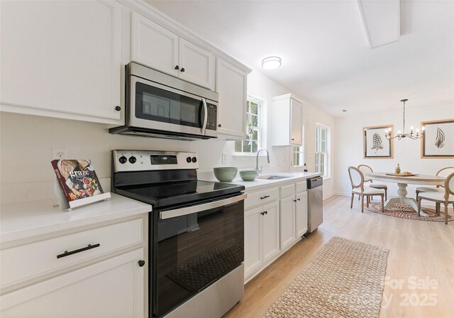 5229 Tarrywood Ln, Charlotte, NC 28205 - kitchen with appliances with stainless steel finishes, a sink, light wood-style flooring, and white cabinetry