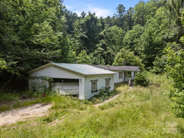 99 Bridges Cove Rd, Leicester, NC 28748 - view of home's exterior with a wooded view and metal roof