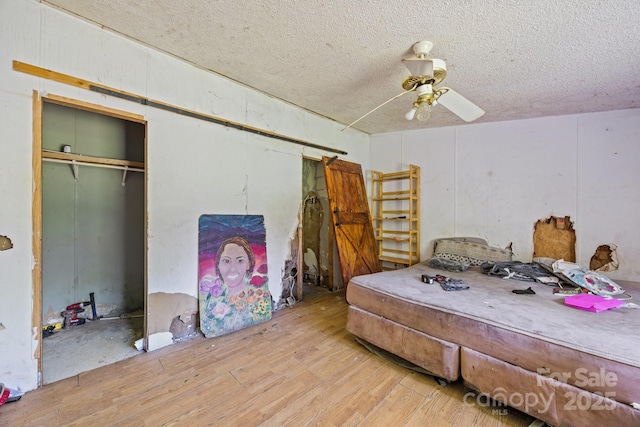 99 Bridges Cove Rd, Leicester, NC 28748 - bedroom featuring wood finished floors, a textured ceiling, a closet, and a ceiling fan