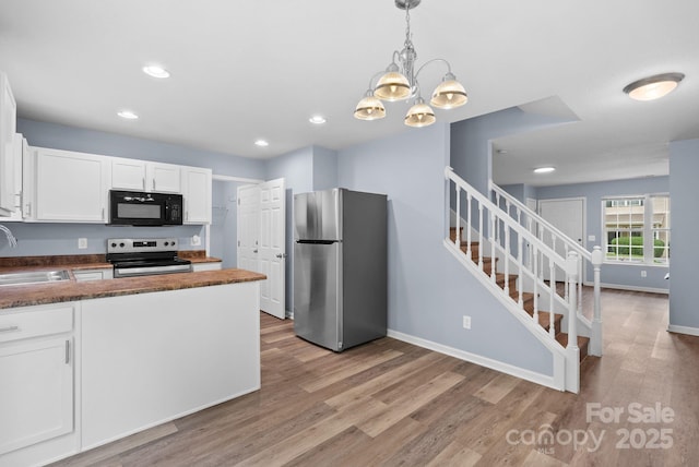 120 Alpine Ridge Dr, Asheville, NC 28803 - kitchen featuring appliances with stainless steel finishes, white cabinetry, light wood-style flooring, a chandelier, and recessed lighting