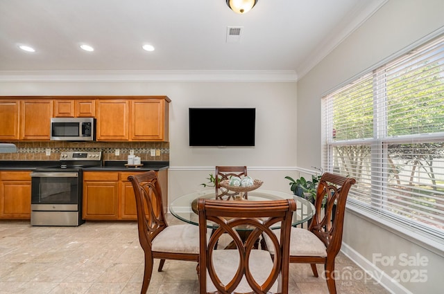 13622 Stringfellow Ln, Charlotte, NC 28278 - kitchen with appliances with stainless steel finishes, brown cabinetry, dark countertops, ornamental molding, and backsplash