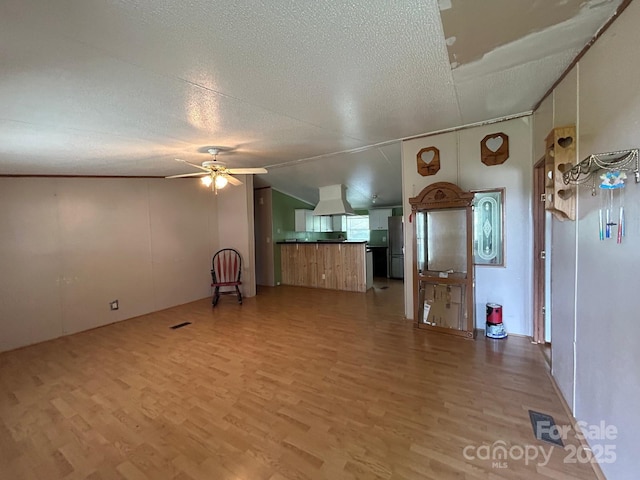 121 J F Morris Dr, Waynesville, NC 28786 - unfurnished living room featuring wood finished floors, ceiling fan, a textured ceiling, and lofted ceiling