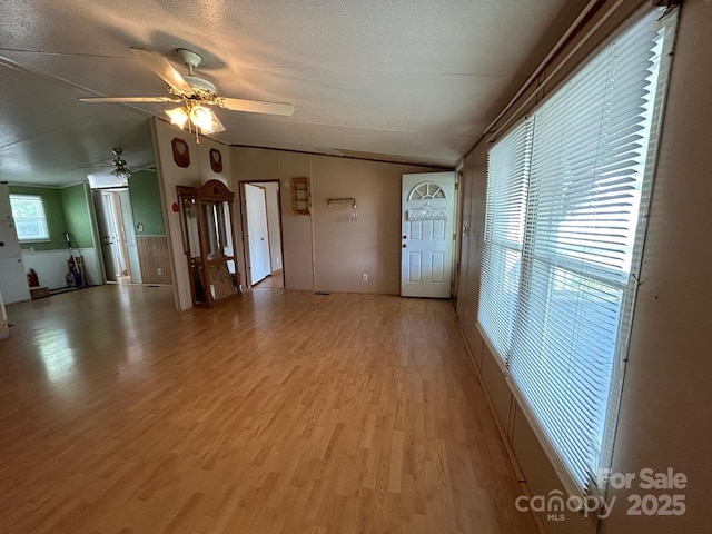 121 J F Morris Dr, Waynesville, NC 28786 - unfurnished living room featuring lofted ceiling, light wood-type flooring, a textured ceiling, and ceiling fan