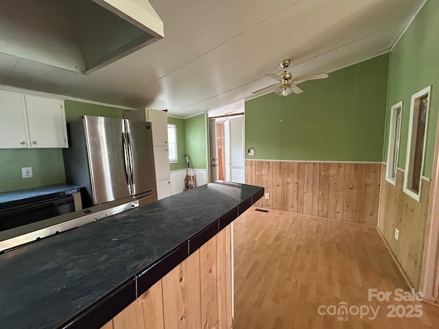 121 J F Morris Dr, Waynesville, NC 28786 - kitchen with freestanding refrigerator, wood finished floors, ceiling fan, wainscoting, and wall chimney range hood