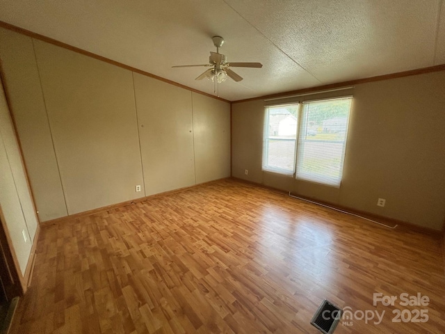 121 J F Morris Dr, Waynesville, NC 28786 - empty room with crown molding, a ceiling fan, light wood-style flooring, baseboards, and a textured ceiling