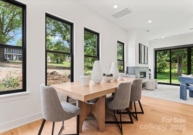4117 Sarah Dr, Charlotte, NC 28217 - dining area featuring a fireplace, light wood-style floors, and recessed lighting