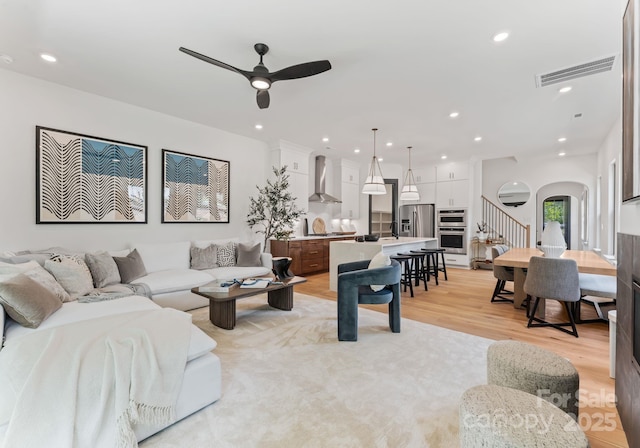 4117 Sarah Dr, Charlotte, NC 28217 - living room featuring a ceiling fan, recessed lighting, light wood-type flooring, stairs, and arched walkways