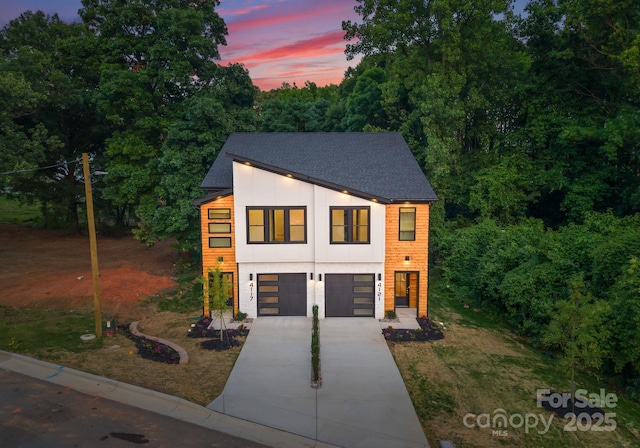4117 Sarah Dr, Charlotte, NC 28217 - contemporary home with concrete driveway, an attached garage, roof with shingles, and a yard