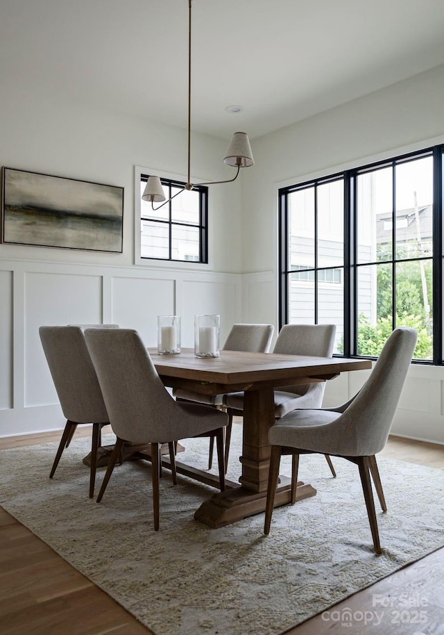 408 Ideal Way, Charlotte, NC 28203 - dining space with a decorative wall, light wood finished floors, a chandelier, and wainscoting
