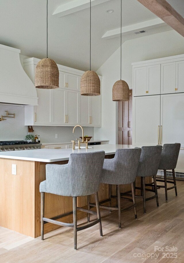 408 Ideal Way, Charlotte, NC 28203 - kitchen with custom exhaust hood, light wood-type flooring, light countertops, and white cabinets
